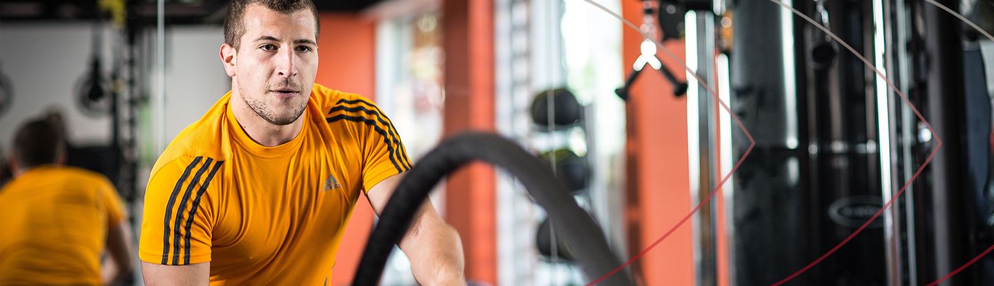 Man exercising with battle ropes in the university gym.