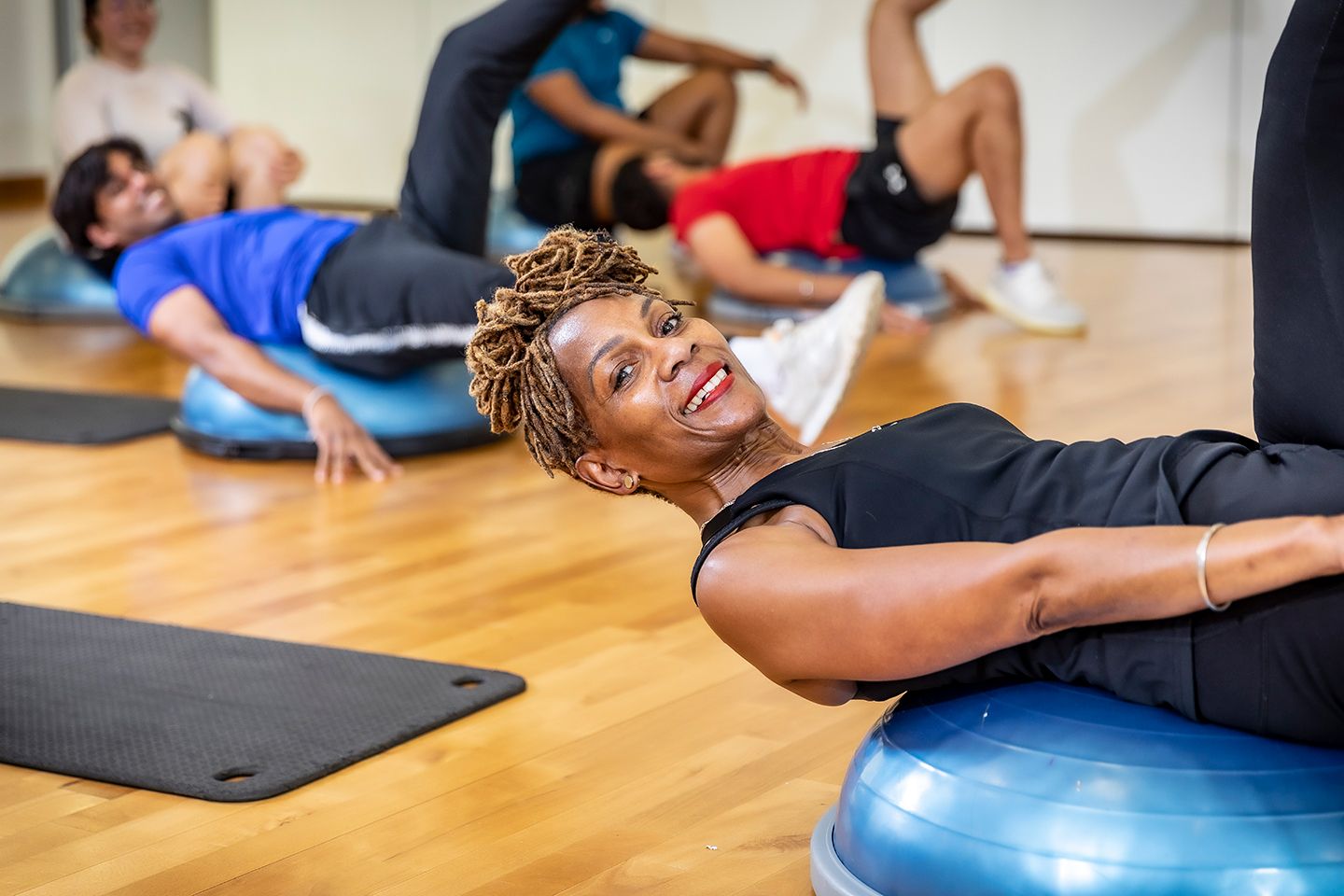 Older woman exercising with a balance ball during a group fitness class.