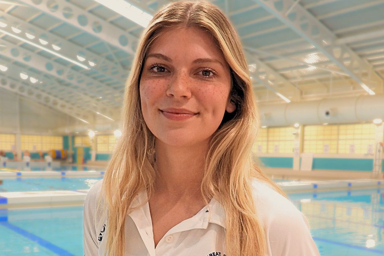 Woman smiling by the side of a swimming pool