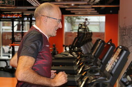 Older adult running on a treadmill in a gym