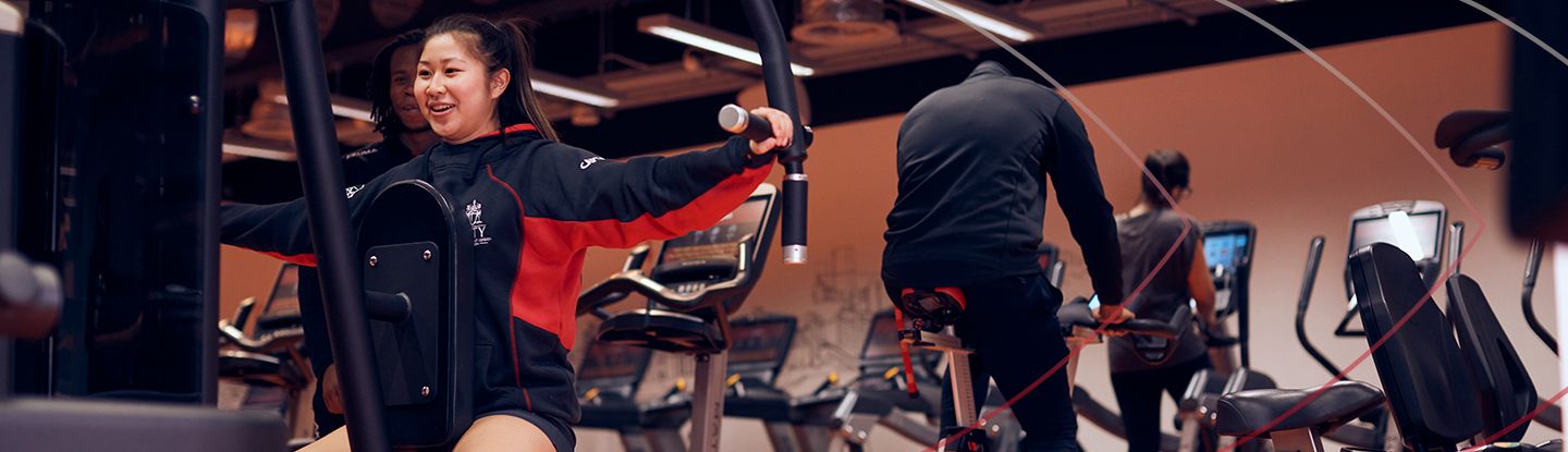 Woman working out on strength training machine at CitySport gym.